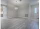 Open-concept living room with light-colored wood floors and a view of the entry door and arched hallway at 1016 Eagles Lndg, Leesburg, FL 34748