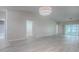 Bright living room showcasing wood-look flooring, neutral walls, and access to a screened lanai at 1016 Eagles Lndg, Leesburg, FL 34748