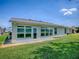 Back exterior view featuring the enclosed patio, and a well-maintained lawn at 1016 Eagles Lndg, Leesburg, FL 34748