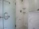 Close-up of a modern shower with marble-patterned walls, glass door, and sleek fixtures at 1016 Eagles Lndg, Leesburg, FL 34748