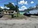Street view of two modest single-story homes with overgrown yards, showcasing the neighborhood's character at 102 Harold St, Leesburg, FL 34748