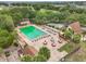 Aerial view of a community pool surrounded by seating, landscaping, and shuffleboard court showcases the community's amenities at 10301 Us Highway 27 # 187, Clermont, FL 34711