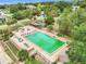 Aerial view of the community pool with lounge chairs and tables surrounded by trees at 10301 Us Highway 27 # 187, Clermont, FL 34711