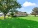 Beautiful backyard featuring an expansive green lawn, mature trees and a screened lanai at 10986 Se 171St Street Rd, Summerfield, FL 34491