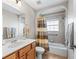 Bright bathroom featuring a tiled shower over tub and a wood vanity with a solid surface top at 10986 Se 171St Street Rd, Summerfield, FL 34491