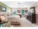Spacious bedroom with large dresser, comfortable bed and a window providing natural light at 10986 Se 171St Street Rd, Summerfield, FL 34491