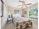 Well-lit bedroom with a ceiling fan, white closet doors, and a serene outdoor view at 10986 Se 171St Street Rd, Summerfield, FL 34491