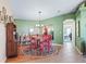 Cozy dining area with hardwood flooring and arched doorway with green walls and red chairs at 10986 Se 171St Street Rd, Summerfield, FL 34491