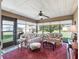 Bright, enclosed lanai boasts an abundance of windows, ceiling fan, and cozy furniture at 10986 Se 171St Street Rd, Summerfield, FL 34491