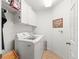 Bright laundry room with white washer and dryer, upper cabinets and tile flooring at 10986 Se 171St Street Rd, Summerfield, FL 34491