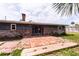 Brick patio with wooden stepdown complements the home's gray siding and brick foundation in the backyard at 110 River Beach Dr, Ormond Beach, FL 32176