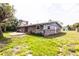 Spacious backyard featuring a patio, lush green grass, and home exterior with gray siding at 110 River Beach Dr, Ormond Beach, FL 32176