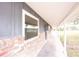 A covered front porch is supported by white columns and has a brick facade and a view of the lawn at 110 River Beach Dr, Ormond Beach, FL 32176