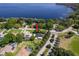 Aerial view of a lakeside home with a manicured lawn and mature trees at 11036 Bronson Rd, Clermont, FL 34711