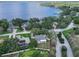 Aerial view of a lakeside home with a manicured lawn and mature trees at 11036 Bronson Rd, Clermont, FL 34711