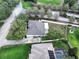 Aerial view of a home with a manicured lawn, mature trees, and backyard patio at 11036 Bronson Rd, Clermont, FL 34711