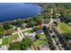 Aerial view of a home near a lake with a manicured lawn and mature trees at 11036 Bronson Rd, Clermont, FL 34711