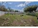 Large back yard with a white vinyl fence, small trees, and lawn furniture at 11036 Bronson Rd, Clermont, FL 34711