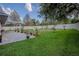 Well-maintained backyard with a patio, mature trees, and a white fence at 11036 Bronson Rd, Clermont, FL 34711