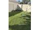 Lush green backyard featuring a lawn, privacy fence and access gate at 11036 Bronson Rd, Clermont, FL 34711
