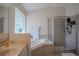 Bathroom featuring a glass shower, a soaking tub with tile surround, and bright, natural light at 11036 Bronson Rd, Clermont, FL 34711