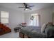 Bedroom featuring a unique round chair, decorative screen, and modern ceiling fan at 11036 Bronson Rd, Clermont, FL 34711