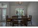Cozy dining room with a rustic table set, large windows, and modern pendant lighting at 11036 Bronson Rd, Clermont, FL 34711