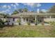 View of the house exterior with covered patio and well-manicured lawn at 11036 Bronson Rd, Clermont, FL 34711