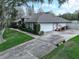 Spacious home featuring an attached two-car garage and long driveway with mature landscaping at 11036 Bronson Rd, Clermont, FL 34711