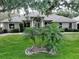 Charming home featuring lush landscaping and a well-manicured lawn with palm trees at 11036 Bronson Rd, Clermont, FL 34711