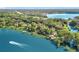 Scenic aerial view of waterfront property with a boat gracefully cruising on the lake at 1107 Northshore Dr, Eustis, FL 32726