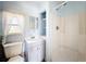 Bathroom with a shower, white vanity, toilet, and a window with natural light at 1107 Northshore Dr, Eustis, FL 32726