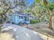 Inviting home exterior featuring a cozy screened porch, mature trees, and a well-maintained driveway at 1107 Northshore Dr, Eustis, FL 32726