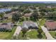 An aerial view of a home showcasing its spacious yard, complemented by mature trees and a long driveway at 11437 Alameda Sandra Dr, Clermont, FL 34711