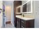 Stylish bathroom with a modern vanity, illuminated mirror, and dark wood cabinets at 11437 Alameda Sandra Dr, Clermont, FL 34711