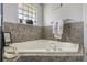 Relaxing bathroom featuring a luxurious corner tub with modern fixtures and stylish tile at 11437 Alameda Sandra Dr, Clermont, FL 34711