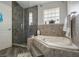A relaxing bathroom features a soaking tub, glass shower, and stone accents at 11437 Alameda Sandra Dr, Clermont, FL 34711