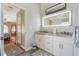 Bright bathroom featuring double sinks, granite countertops, modern lighting, and wood-look tile floors at 11437 Alameda Sandra Dr, Clermont, FL 34711