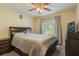 A comfortably furnished bedroom features a ceiling fan and a window with curtains at 11437 Alameda Sandra Dr, Clermont, FL 34711