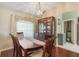 The dining room features hardwood floors, a large window with elegant curtains, and a decorative china cabinet at 11437 Alameda Sandra Dr, Clermont, FL 34711