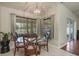 A dining room features a glass table, chandelier, and large windows at 11437 Alameda Sandra Dr, Clermont, FL 34711
