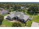 Beautiful single-story home with a well-manicured lawn, landscape beds, and a white fence surrounding the backyard at 11437 Alameda Sandra Dr, Clermont, FL 34711