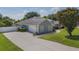 An inviting view of this house highlighting an attached two-car garage and well-maintained lawn and landscaping at 11437 Alameda Sandra Dr, Clermont, FL 34711