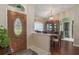 Interior view showcases the foyer with an ornate glass door, wood floors, and dining room with china cabinet at 11437 Alameda Sandra Dr, Clermont, FL 34711