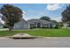 Charming home features a well-manicured lawn, mature trees, and inviting curb appeal at 11437 Alameda Sandra Dr, Clermont, FL 34711