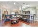 A expansive living area is shown leading into the kitchen, featuring hardwood floors and a comfortable sectional sofa at 11437 Alameda Sandra Dr, Clermont, FL 34711