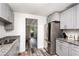 A bright kitchen featuring gray cabinets, granite counters, and stainless steel refrigerator at 121 Mason Park Dr, Daytona Beach, FL 32117
