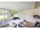 Screened porch with outdoor seating and a white table and green patterned rug at 121 Mason Park Dr, Daytona Beach, FL 32117