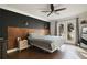 Inviting main bedroom featuring a wooden accent wall, ceiling fan, and sliding door access to a balcony at 1226 Overlook Rd, Eustis, FL 32726