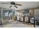Enclosed patio area with an outdoor kitchen, bar area, ceiling fan, and seating overlooking a lake at 1226 Overlook Rd, Eustis, FL 32726